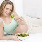 Pregnant woman eats vegetables