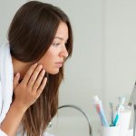 Беременная смотрится в зеркало