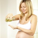 беременная женщина лье масло на руку