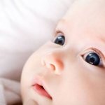 How does a newborn baby see in the first month?