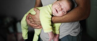 Baby sleeps in dad's arms