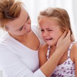 Mom calms a crying girl