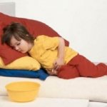 Ребёнок лежит, держась за живот