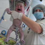 a newborn baby with a tied umbilical cord