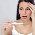 женщина смотрит на термометр